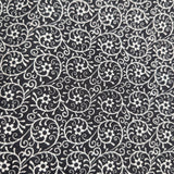 Close-up of the Black Floral Welding Cap fabric showing white floral and vine patterns on black cotton — handcrafted by HD Welding Hats.
