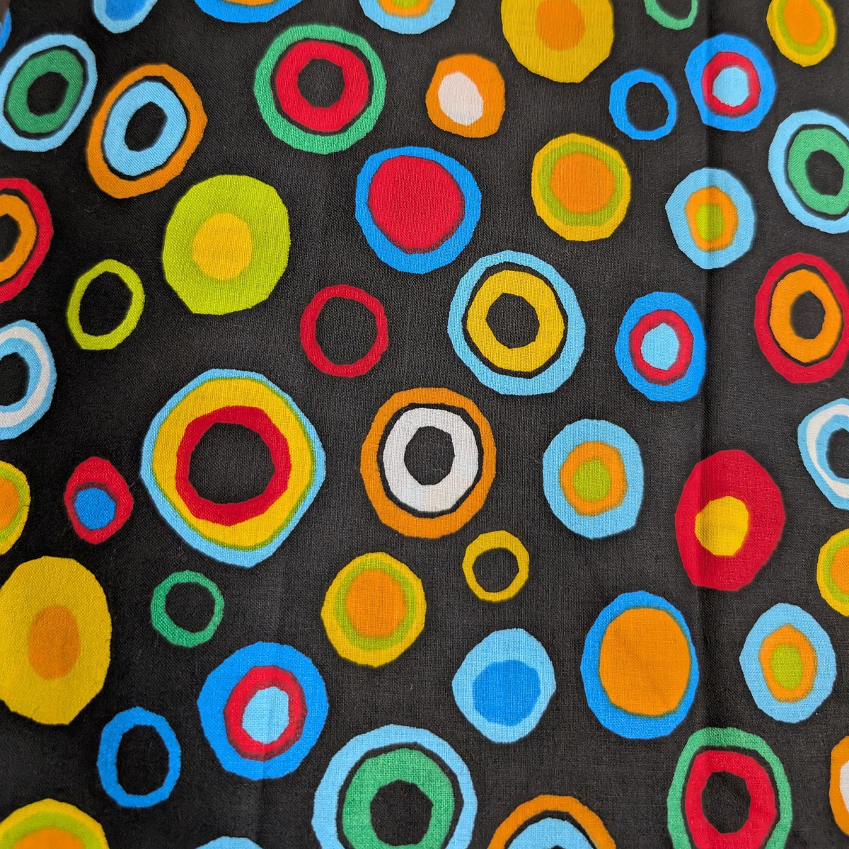Black cotton fabric with multicolored concentric circle pattern used for the HD Welding Hats Circles Welding Hat.
