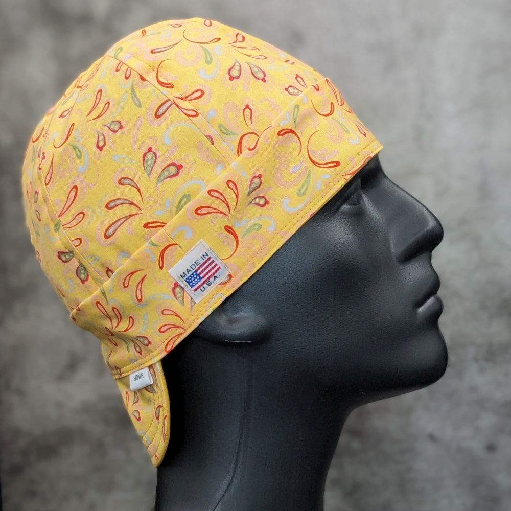 Frontier Paisley Yellow Welding Cap featuring golden-yellow cotton fabric with orange, green, and red paisley design, handcrafted by HD Welding Hats with FR denim brim.