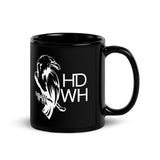 Black glossy ceramic mug featuring white HD Welding Hats logo with crow design, available in 11 oz and 15 oz sizes.