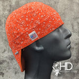 Orange Paisley Bandanna Welding Cap with bright orange cotton and classic white paisley print, handmade in the USA by HD Welding Hats.