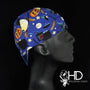 Side view of the Boo! Welding Cap with a Halloween print of pumpkins, witches, and stars on blue cotton — handcrafted by HD Welding Hats.