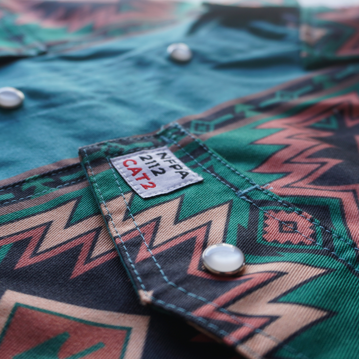 Close-up of a green patterned shirt with a label on a blurred background