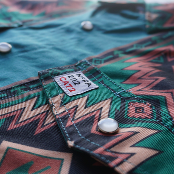 Close-up of a green patterned shirt with a label on a blurred background