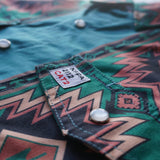 Close-up of a green patterned shirt with a label on a blurred background