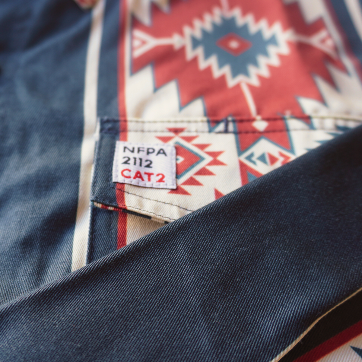 Close-up of a label on a denim shirt with a geometric pattern