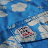 Close-up of a blue fabric with white floral patterns and an NFPA label.