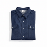 Folded blue denim shirt with white buttons on a white background