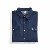 Folded blue denim shirt with white buttons on a white background