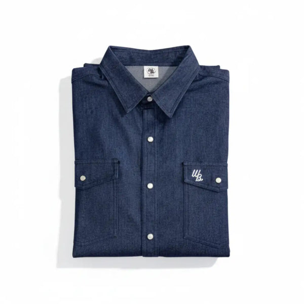 Folded blue denim shirt with white buttons on a white background