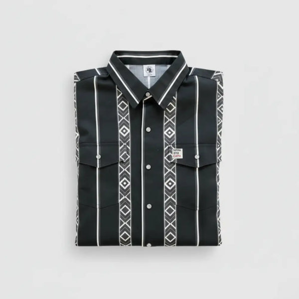 A folded black long-sleeve button-up shirt with white vertical stripes and geometric diamond patterns, displayed on a light gray background.