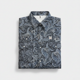 Folded shirt with a blue paisley pattern on a light gray background