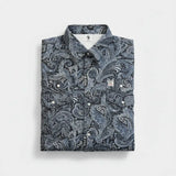 Folded shirt with a blue paisley pattern on a light gray background