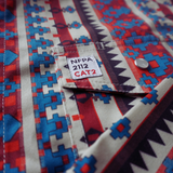Colorful patterned fabric with a NFPA 2112 CAT2 label.