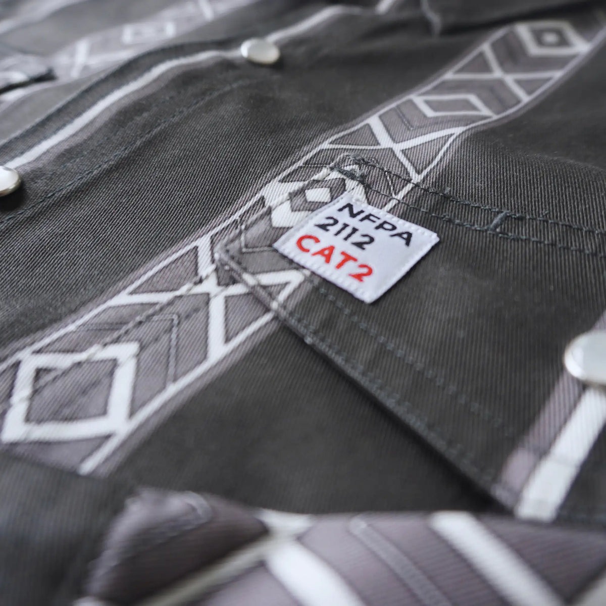 Close-up of a gray work shirt with NFPA 2112 CAT2 label